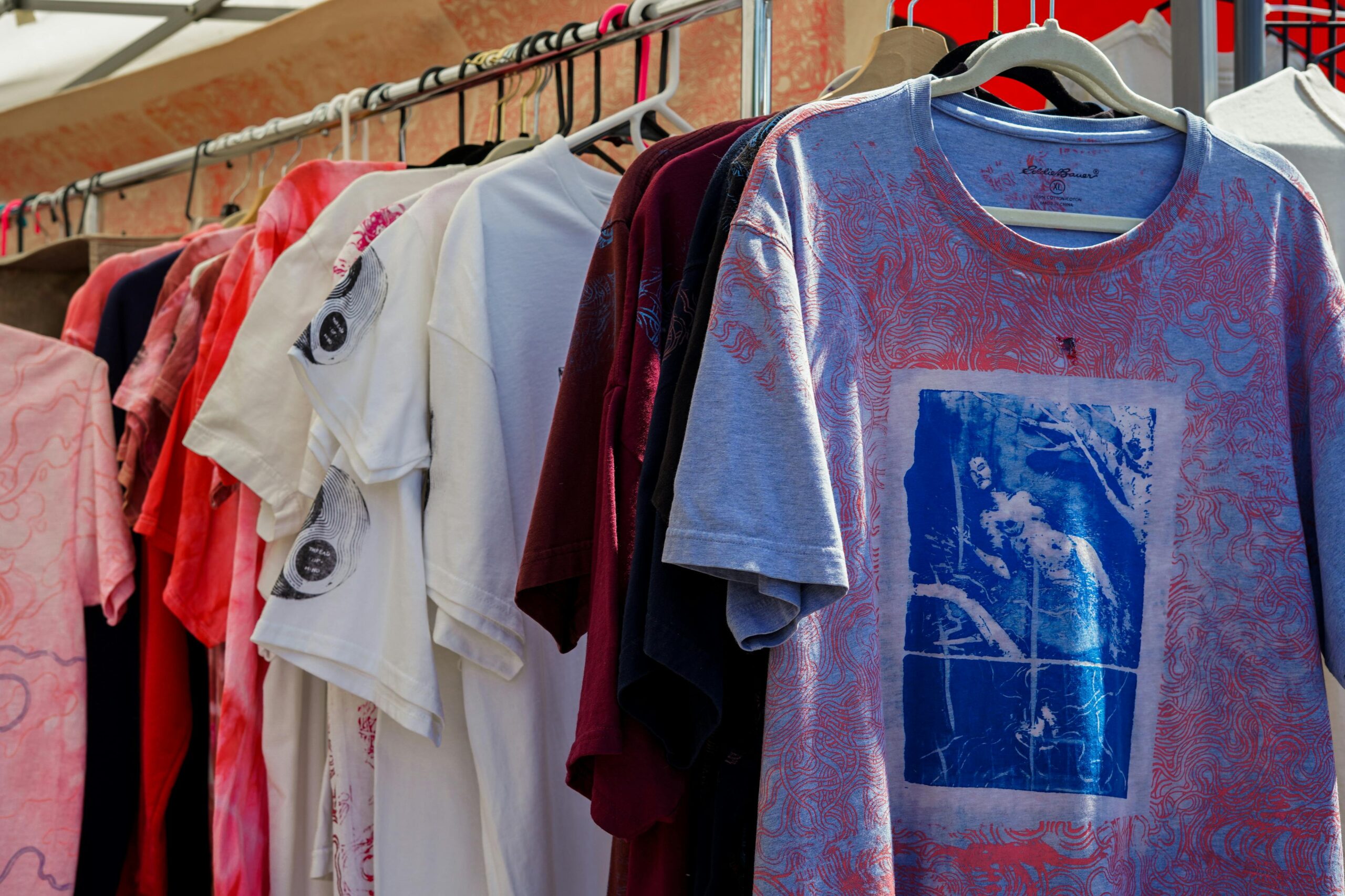 A vibrant display of assorted t-shirts hanging in a market setting, perfect for fashion enthusiasts.